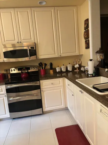 a kitchen with granite countertop a sink a stove and cabinets