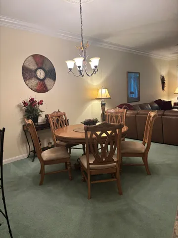 a living room with furniture a chandelier a rug and a large window