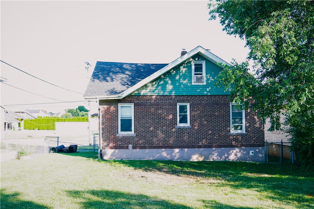 870 Chestnut Street Coplay, PA 18037 - Photo 24 of 24 A classic brick exterior with a distinctive teal gable stands against a clear sky.