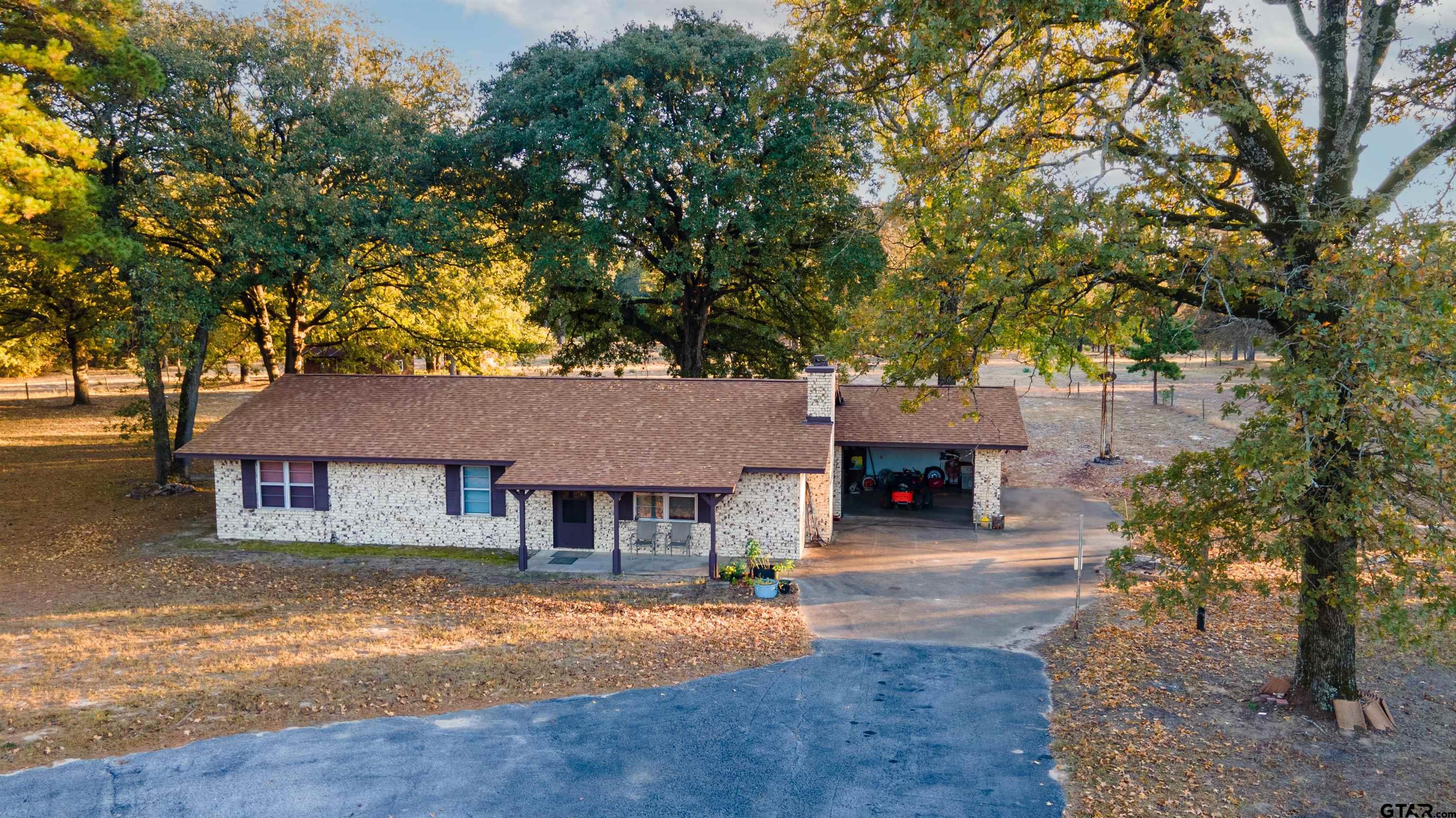 a front view of a house with yard and trees