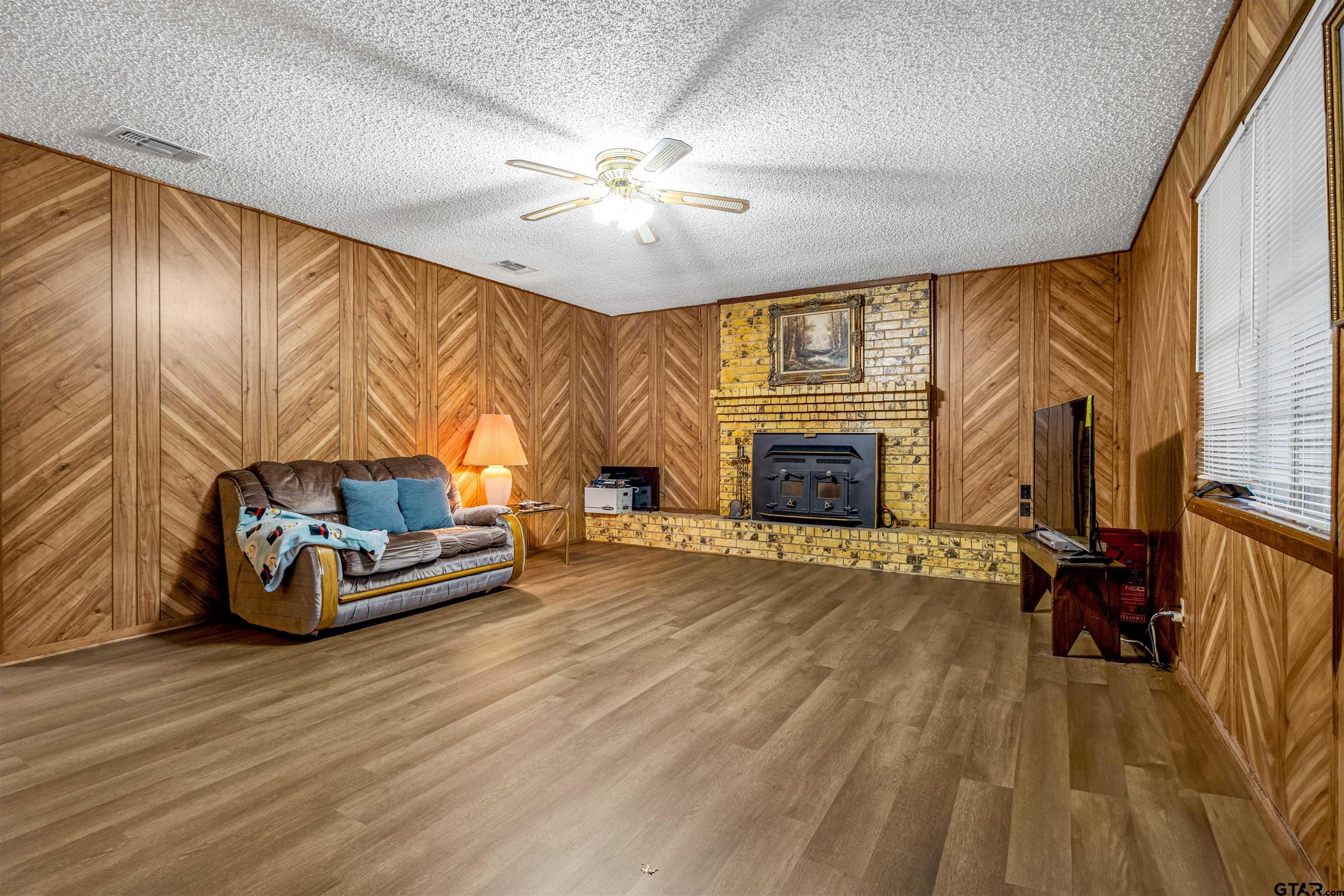 3702 E Highway Quitman, TX 75783 - Photo 9 of 33 a room with wooden floor and a fireplace