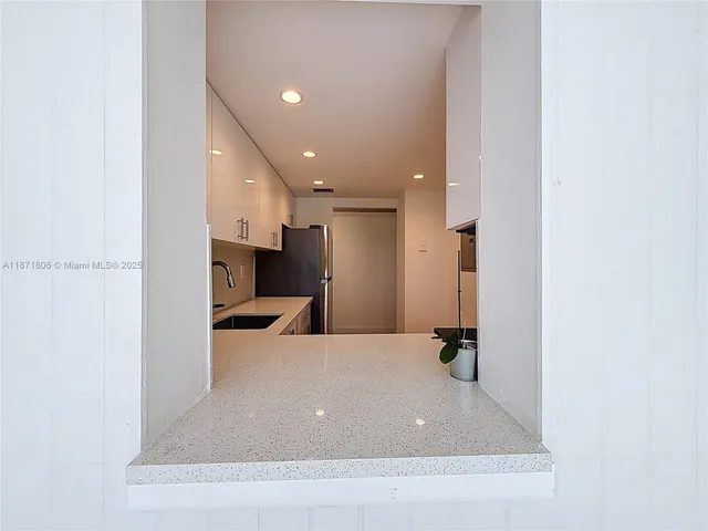 a kitchen with a refrigerator and a stove top oven