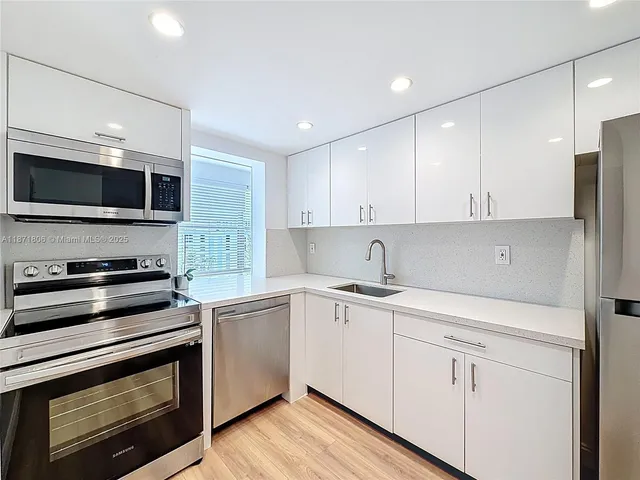 a kitchen with a refrigerator sink and cabinets