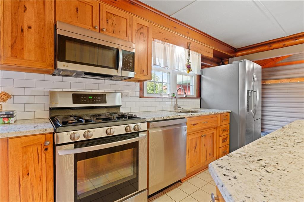 121 Jackson Street Harmony, PA 16037 - Photo 10 of 50 a kitchen with stainless steel appliances granite countertop a stove top oven microwave and refrigerator