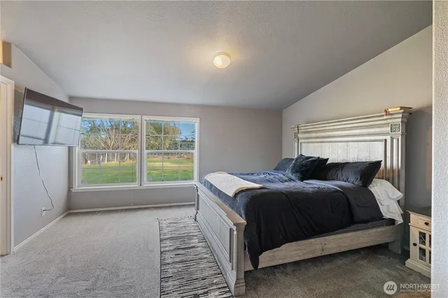 a bed sitting in a bedroom next to a window
