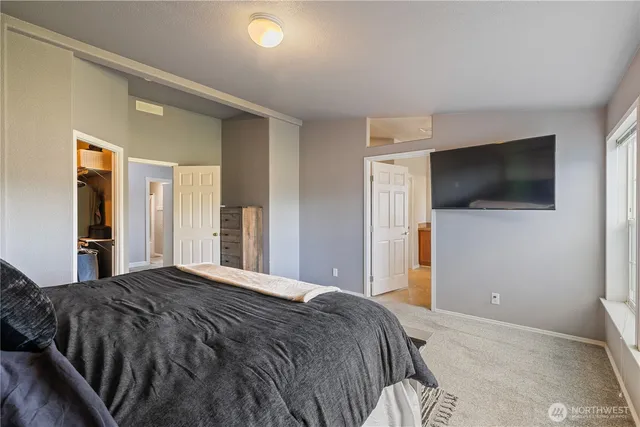 a bedroom with a bed and a flat screen tv