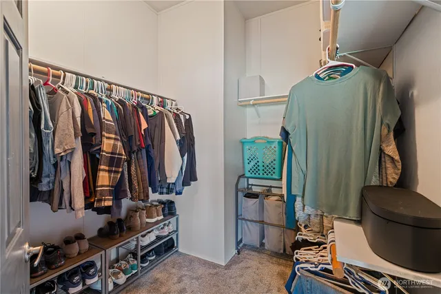 a view of walk in closet with clothes and shoes
