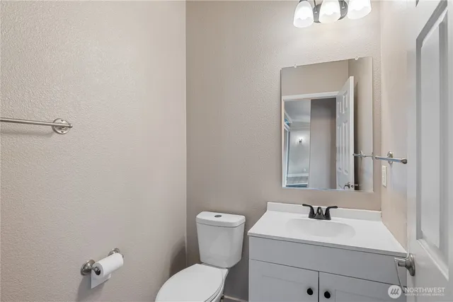 a bathroom with a toilet sink vanity and mirror