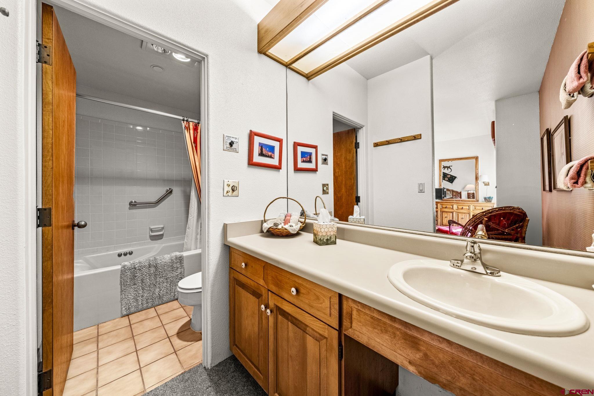 117 Needles Way, Unit 528 Durango, CO 81301 - Photo 15 of 41 a bathroom with a granite countertop sink a mirror and shower