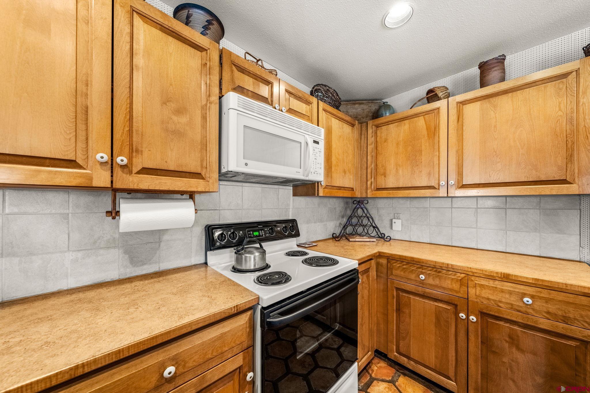 117 Needles Way, Unit 528 Durango, CO 81301 - Photo 26 of 41 a kitchen with stainless steel appliances a stove a sink and a microwave