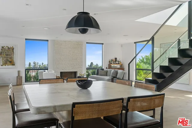 a view of a dining room and livingroom with furniture wooden floor a chandelier