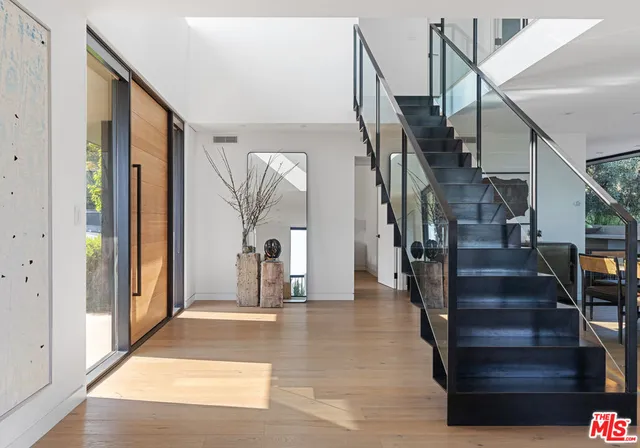 a view of entryway and hall with wooden floor