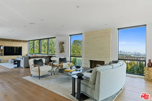 a living room with furniture fireplace and a large window