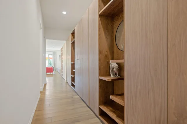 a view of a hallway with wooden floor and staircase