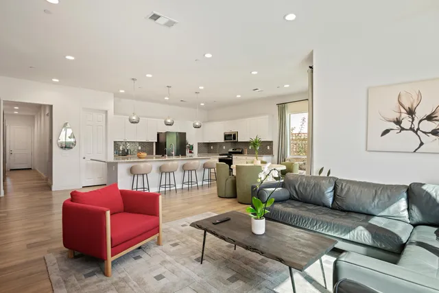 a living room with furniture kitchen view and a table