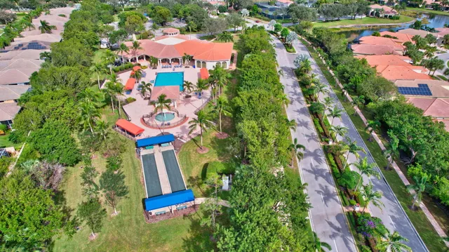 a view of a swimming pool with a lounge chair and palm trees