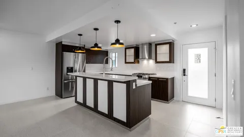 a view of kitchen with refrigerator and white cabinets