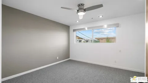 an empty room with a ceiling fan and a window