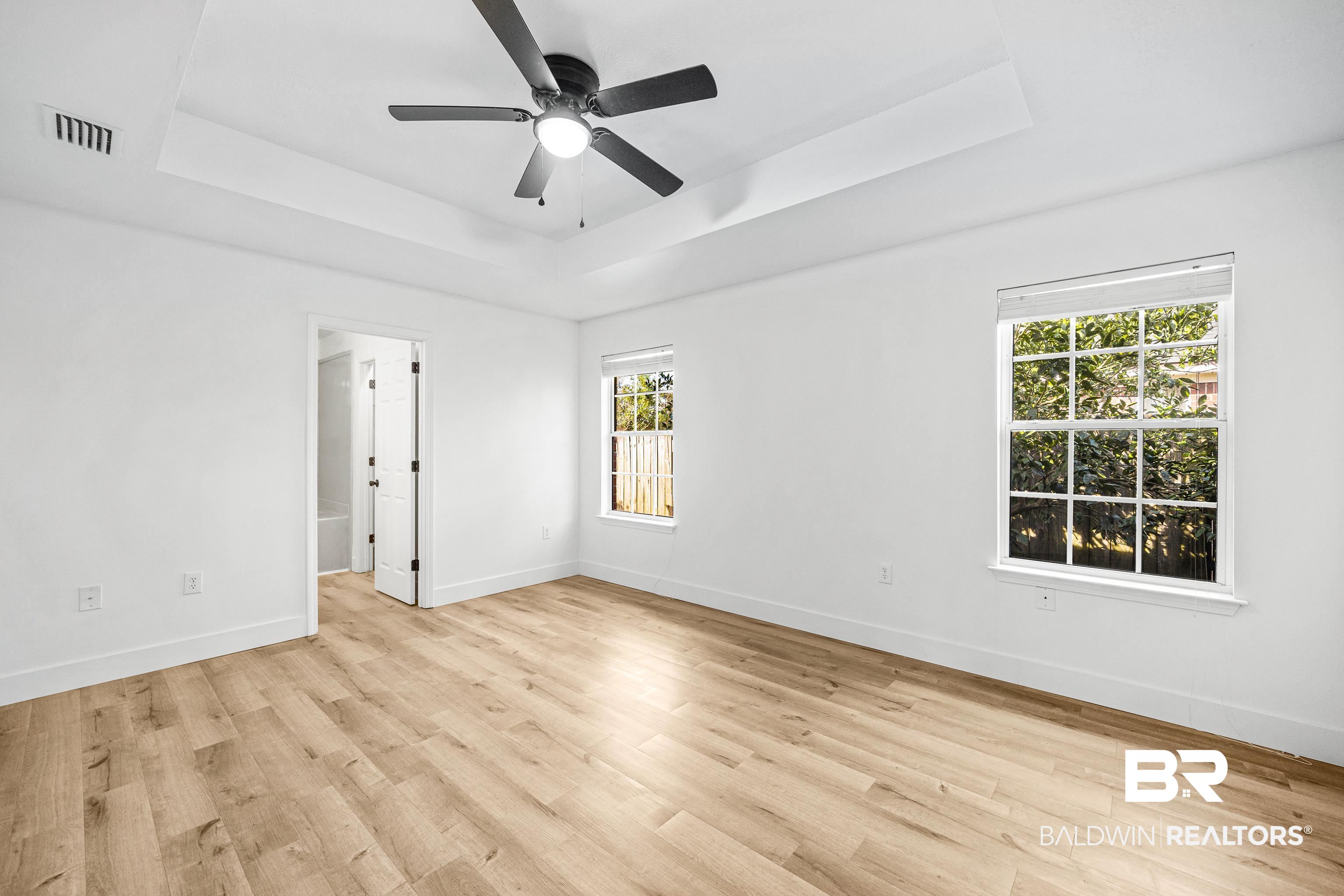9243 Brookshire Loop Daphne, AL 36526 - Photo 8 of 26 Unfurnished room featuring a raised ceiling, ceiling fan, and light hardwood / wood-style floors