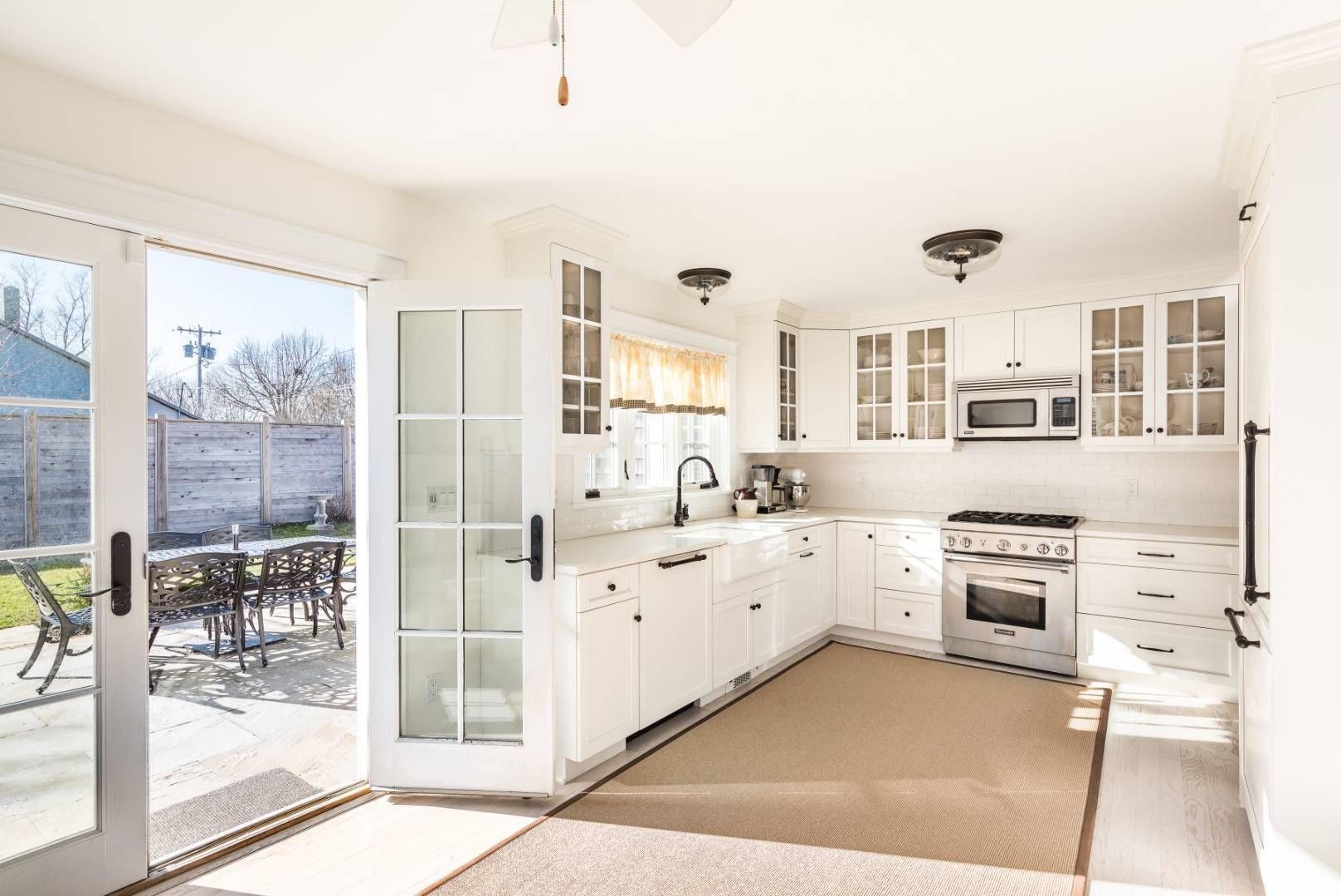 154 Corwith Avenue Bridgehampton, NY 11932 - Photo 11 of 11 a large white kitchen with cabinets a sink and a stove