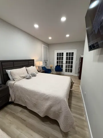 a large bed sitting in a large room with furniture and a wooden floor