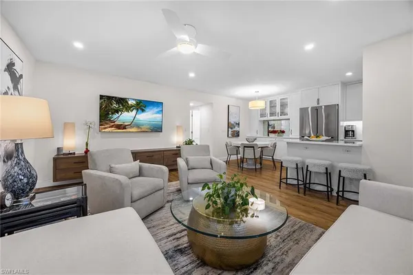 a living room with furniture and a view of kitchen