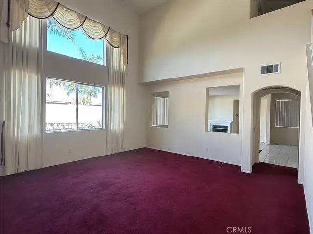 an empty room with windows and chandelier