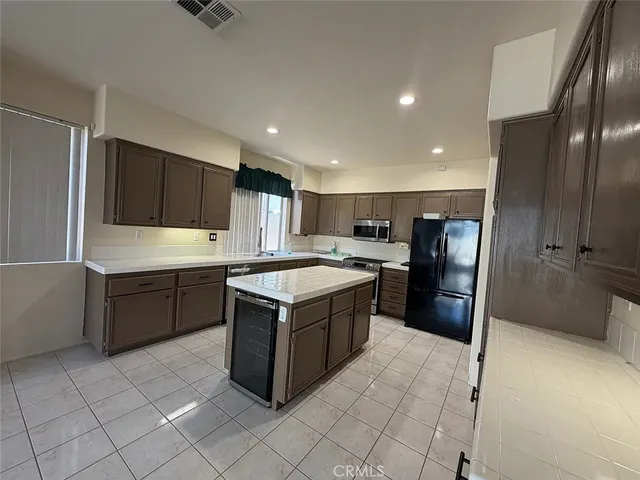 a kitchen with stainless steel appliances granite countertop a refrigerator and a stove top oven