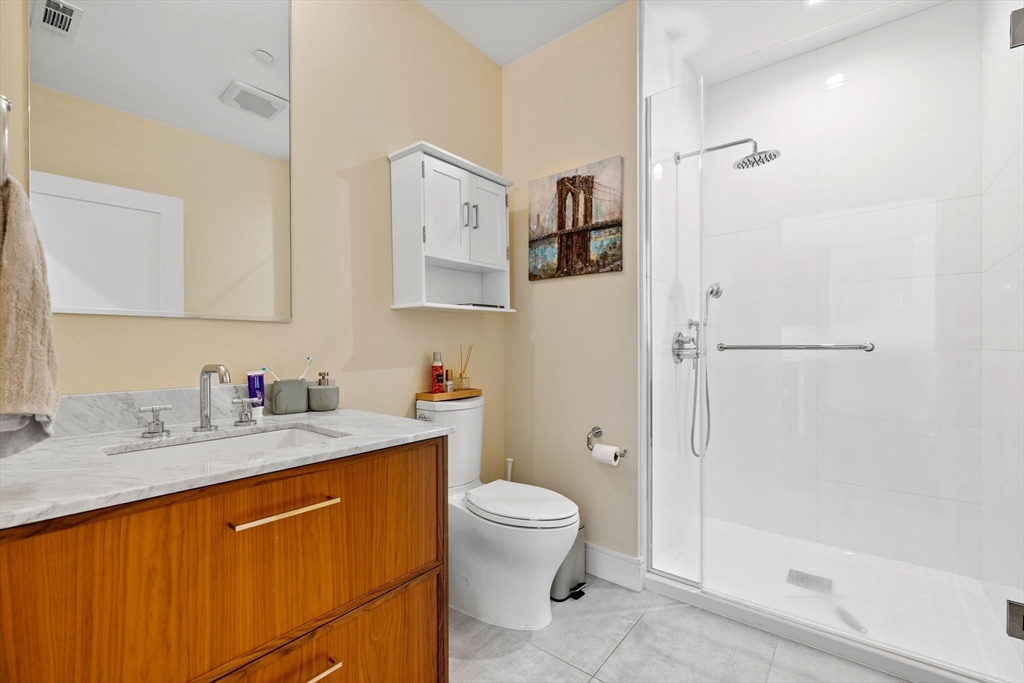 99 Sumner Street, Unit 101 Boston, MA 02128 - Photo 11 of 35 a bathroom with a granite countertop sink toilet and shower