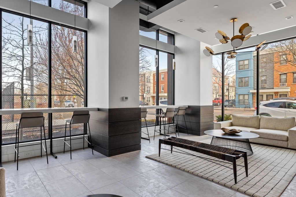 99 Sumner Street, Unit 101 Boston, MA 02128 - Photo 20 of 35 a living room with furniture and a floor to ceiling window