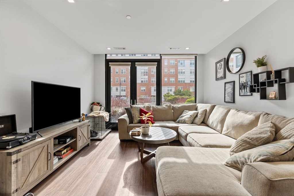 99 Sumner Street, Unit 101 Boston, MA 02128 - Photo 2 of 35 a living room with furniture and a flat screen tv