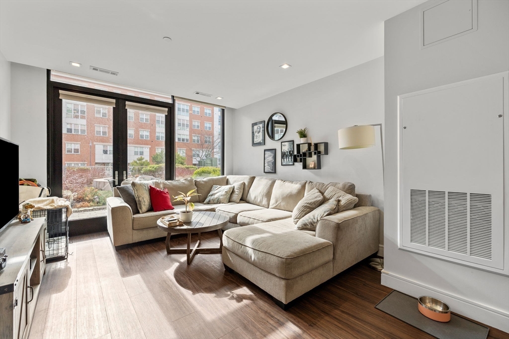 99 Sumner Street, Unit 101 Boston, MA 02128 - Photo 4 of 35 a living room with furniture and large windows