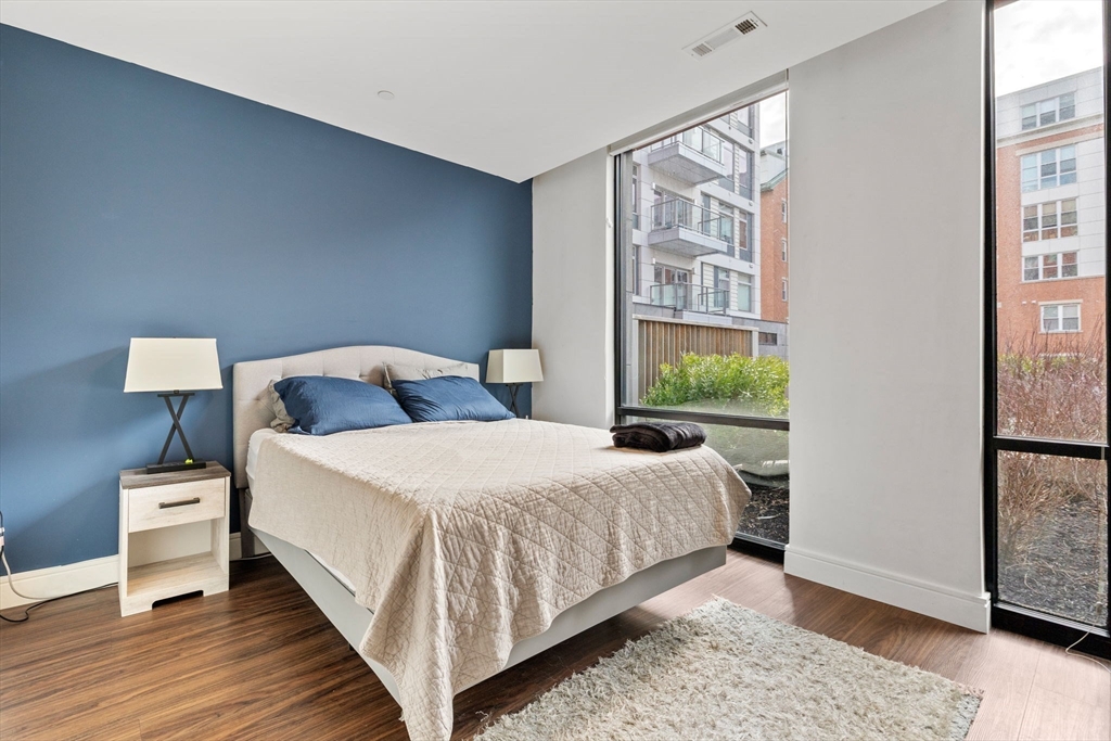 99 Sumner Street, Unit 101 Boston, MA 02128 - Photo 9 of 35 a bedroom with a bed and wooden floor