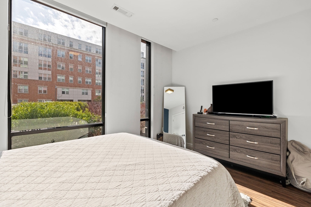 99 Sumner Street, Unit 101 Boston, MA 02128 - Photo 10 of 35 a bedroom with a bed and a flat screen tv