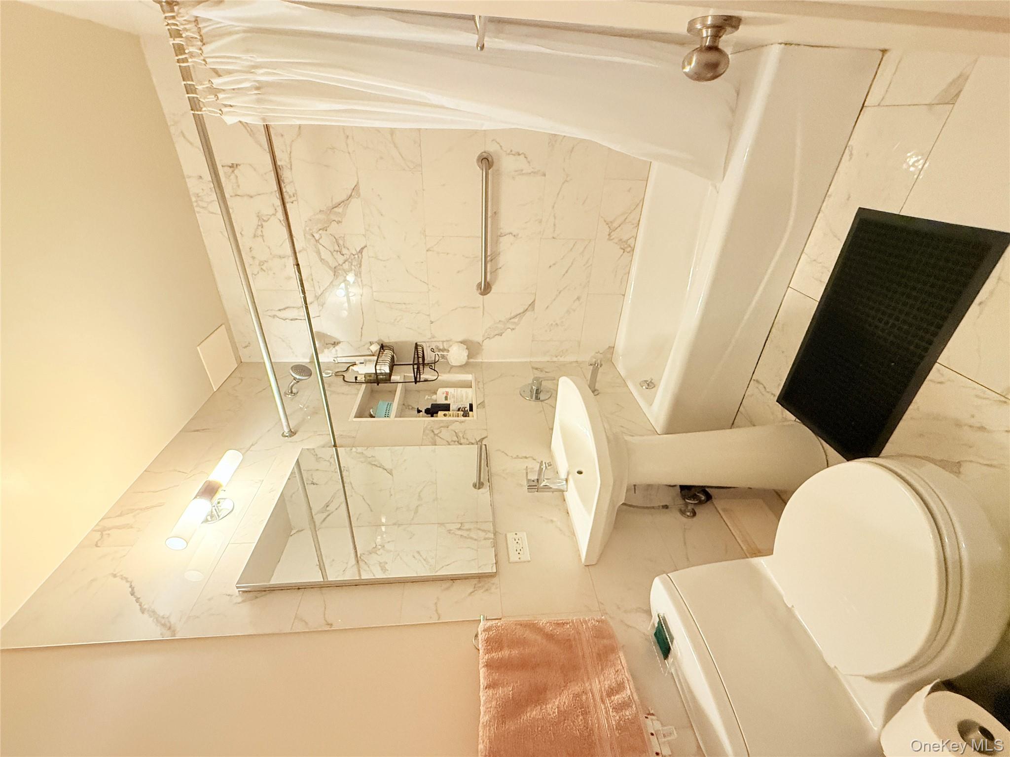 87-10 51st Avenue, Unit 5H Queens, NY 11373 - Photo 14 of 16 a bathroom with a sink a toilet and shower