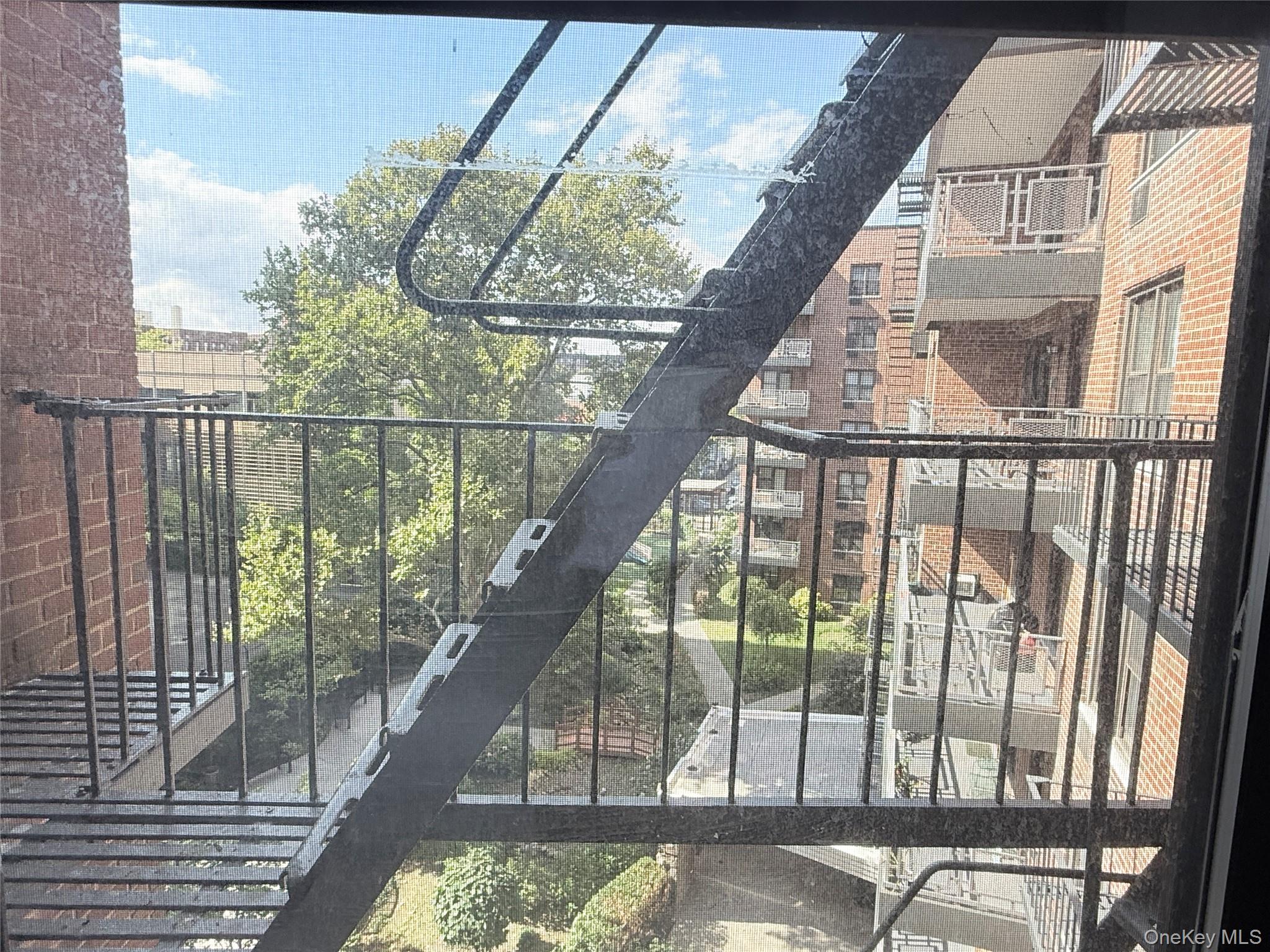 87-10 51st Avenue, Unit 5H Queens, NY 11373 - Photo 16 of 16 a view of staircase with a floor to ceiling window and wooden floor