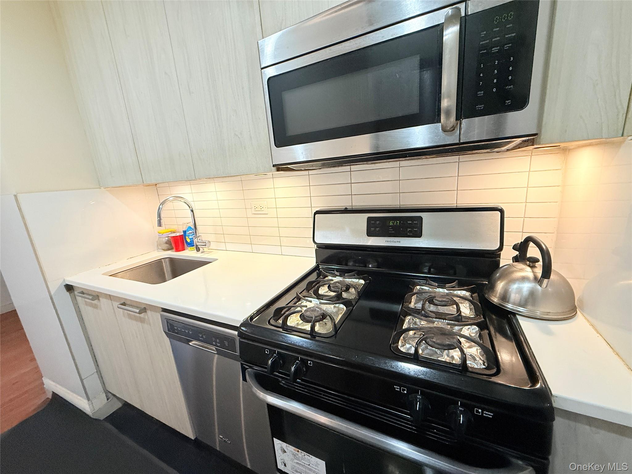 87-10 51st Avenue, Unit 5H Queens, NY 11373 - Photo 10 of 16 a kitchen with a stove and a microwave