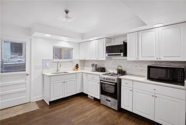 a kitchen with white cabinets and white appliances
