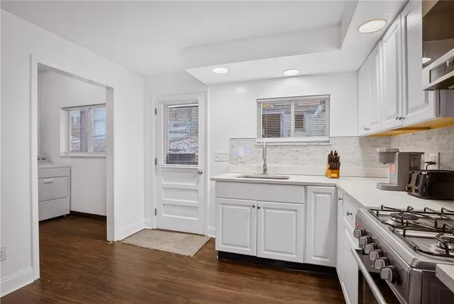 a kitchen with a sink and wooden floor