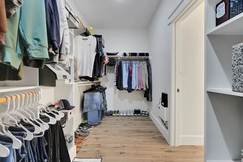 a view of walk in closet with clothes and shoes