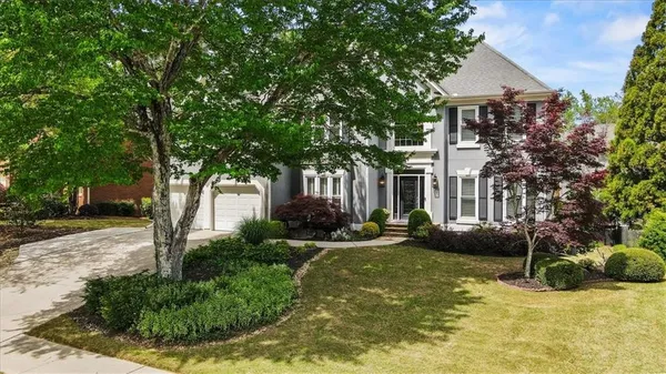 a front view of a house with a yard garage and outdoor seating