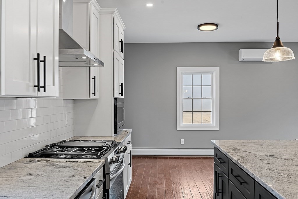1435 South Athol Road Athol, MA 01331 - Photo 9 of 23 a kitchen with granite countertop a stove a sink and white cabinets with wooden floor