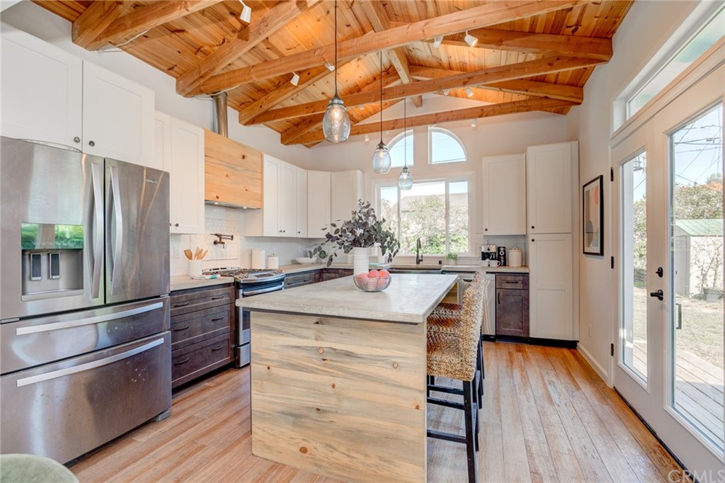 8218 Handley Avenue Los Angeles, CA 90045 - Photo 2 of 20 a kitchen with stainless steel appliances kitchen island granite countertop a refrigerator a sink dishwasher a stove and white countertops with wooden floor