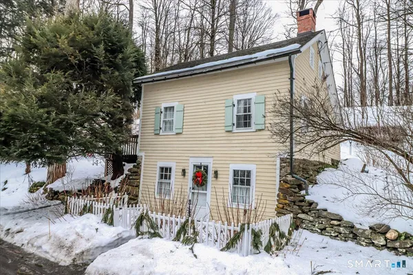 a view of a house with a yard covered in snow
