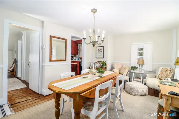 a dining room with furniture a chandelier and wooden floor