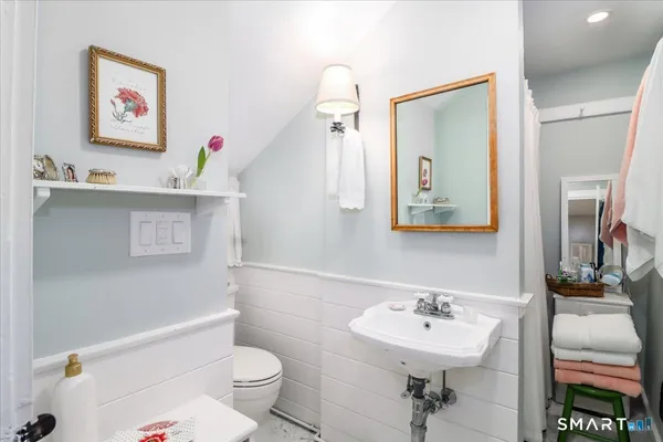 a bathroom with a sink mirror and a toilet