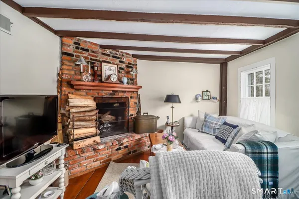 a living room with furniture a flat screen tv and a fireplace