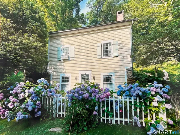 a front view of a house with a yard and fountain