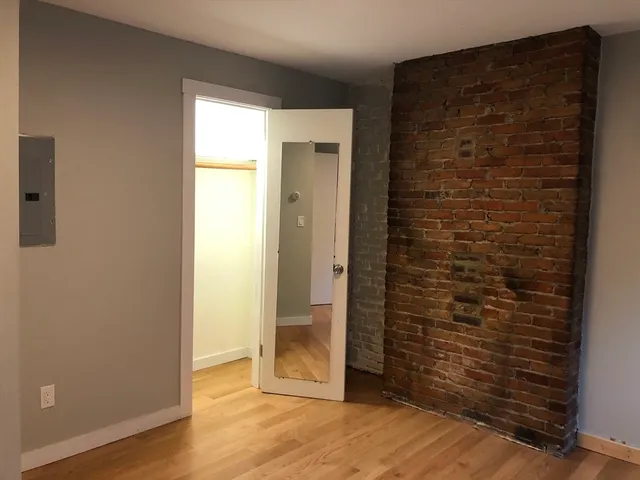an empty room with wooden floor and a window