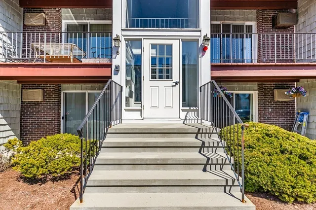 a front view of a house with a garden and plants